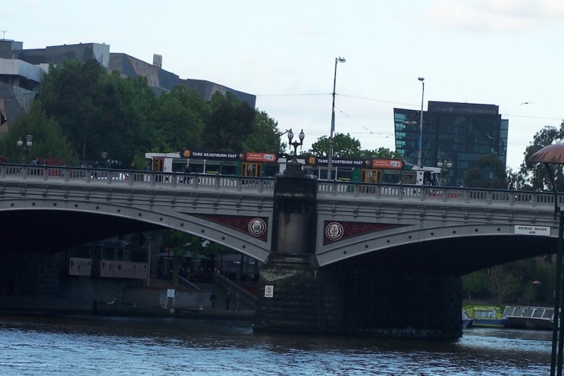 A scenic tourist shot of a tram going over a bridge.