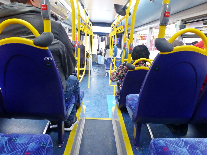 A view from the back seat looking to the front of the bus. Each seat has a USB socket on the back.